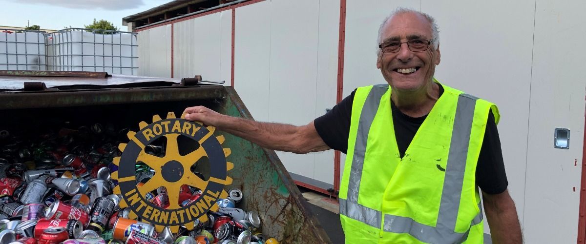 Graham holding a Rotary Sign as he helps a recycling scheme