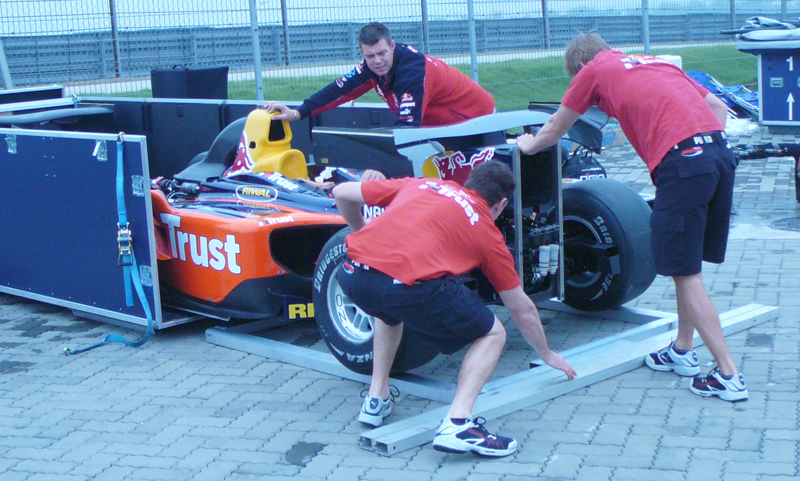 Men moving race car into specially designed flight case