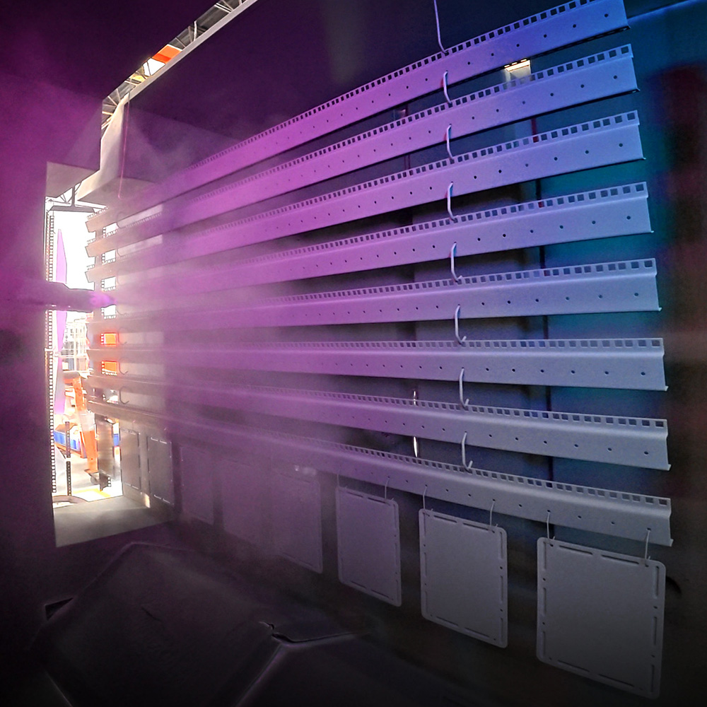 products being sprayed in booth with blue and purple lighting 