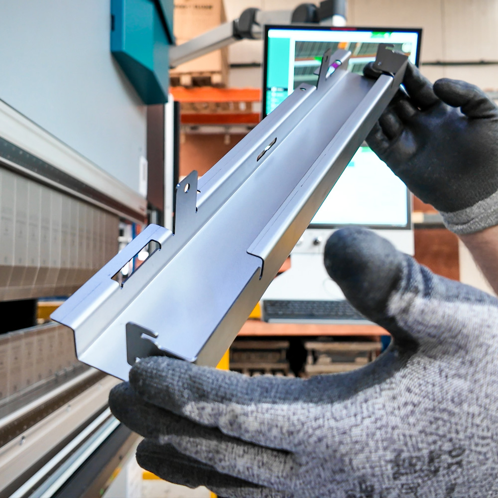 Angled shot of man holding metal product during production