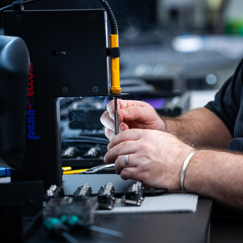 Person soldering cable at Penn Elcom Hastings UK