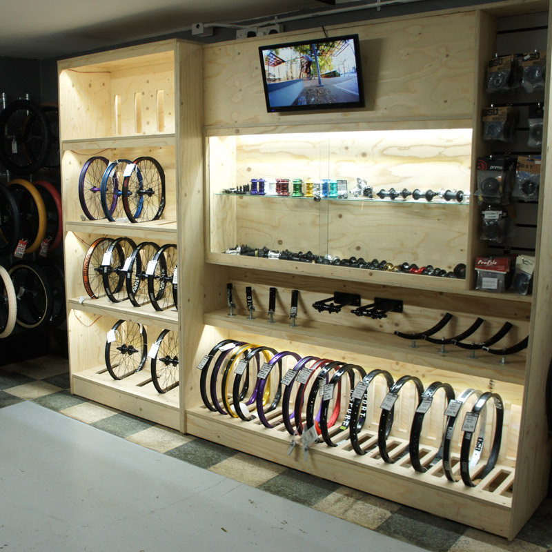 Wooden shelving unit with LED lighting for BMX bike wheels at Source Park