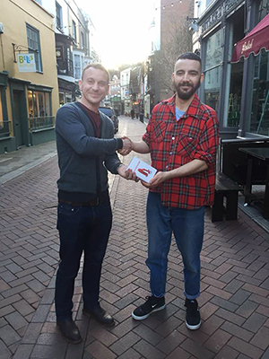 Rob Platt shaking Harry Wiseman's hand, gifting him with DoorJammer from Penn Elcom