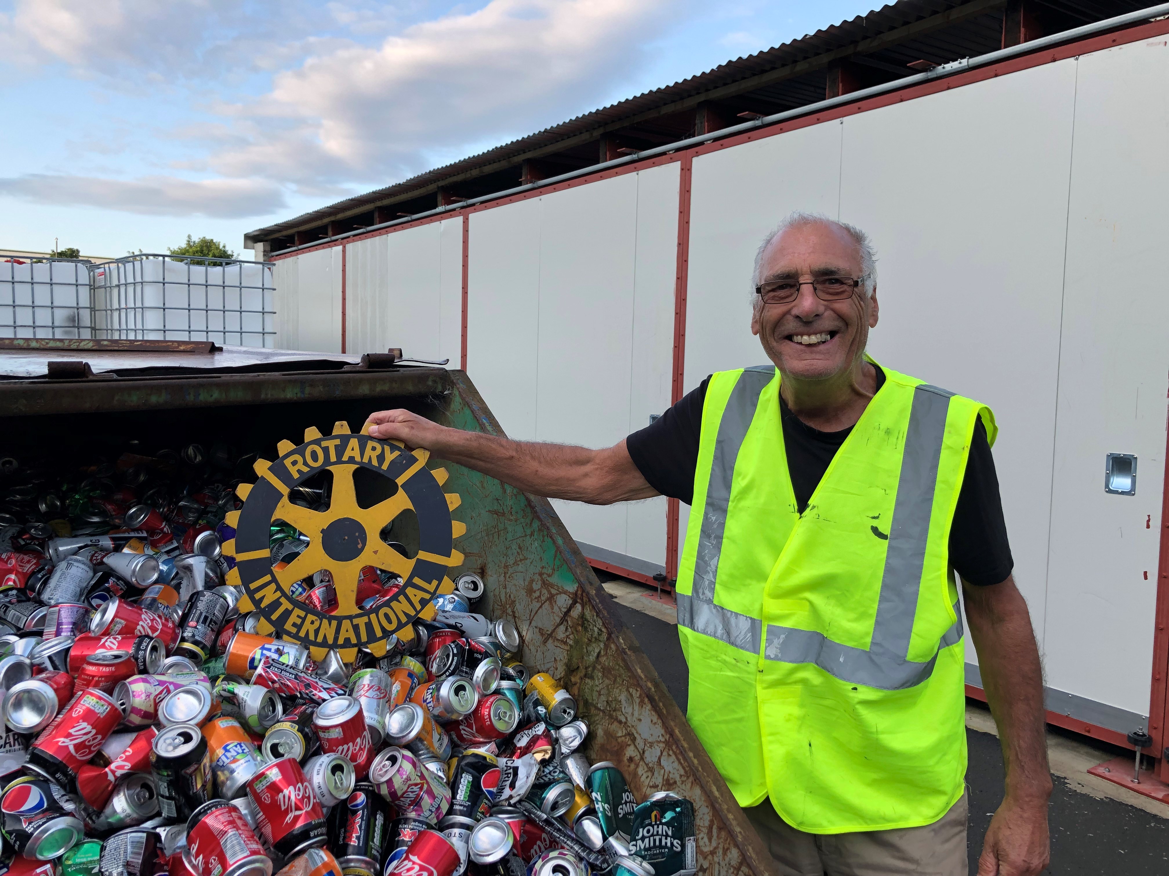 Graham holding Rotary Symbol whilst recycling