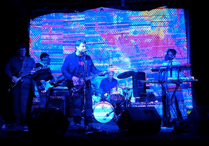 Seaholm Electric gig with full band in front of neon screen