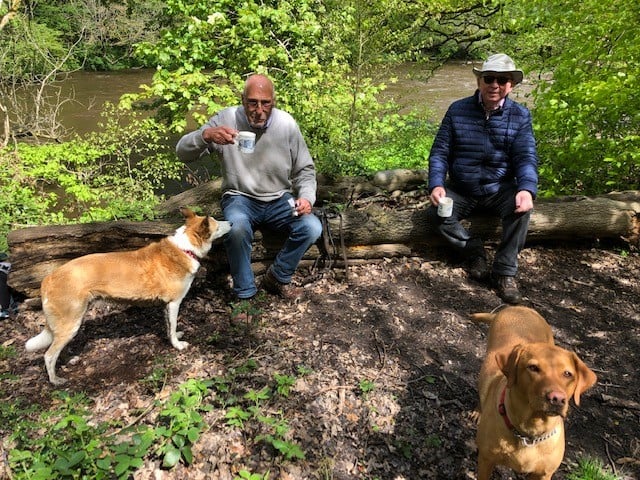 Graham sitting down with a friend and with their dogs